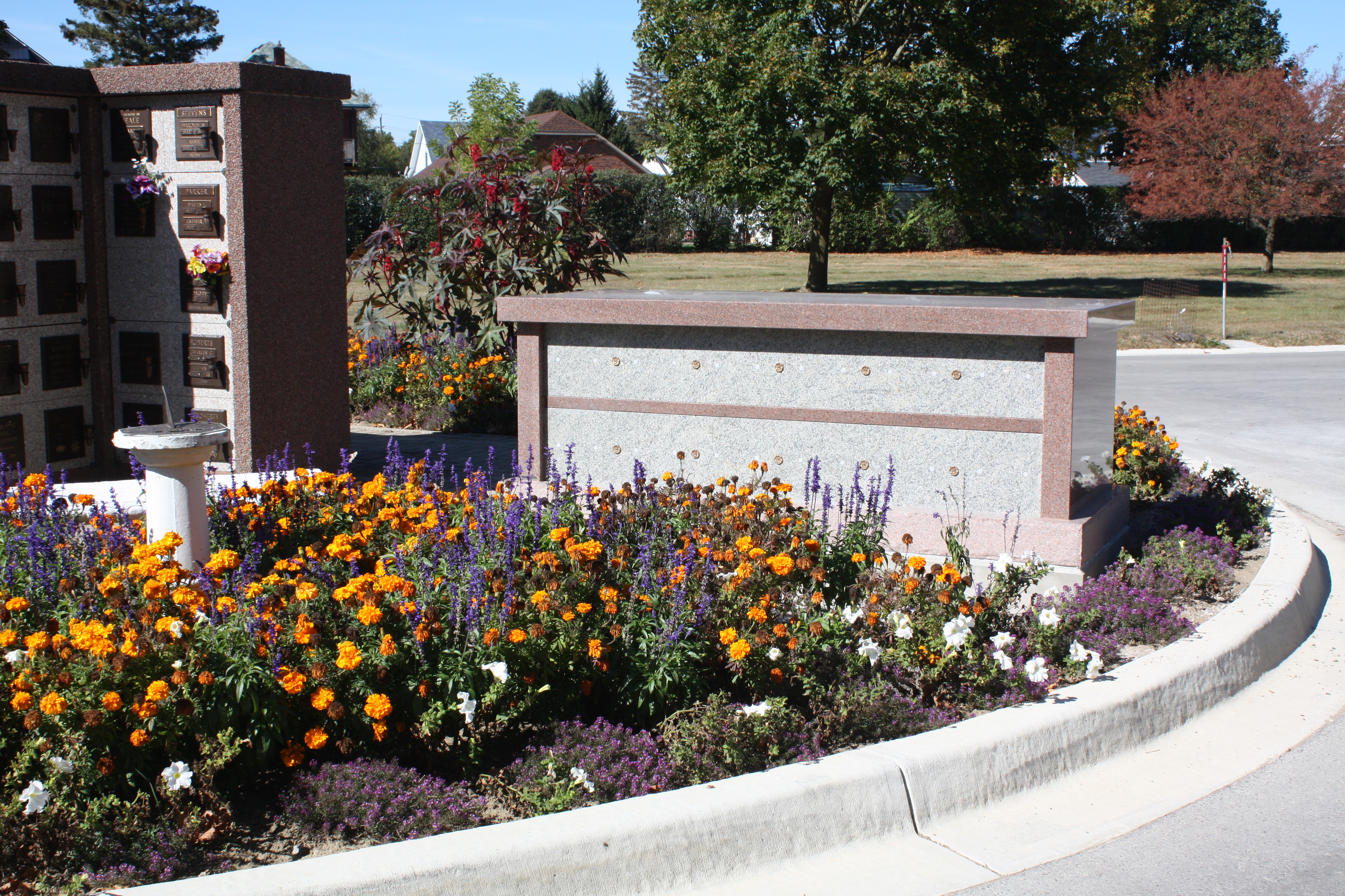 A larger columbaria wall with a praying statue.